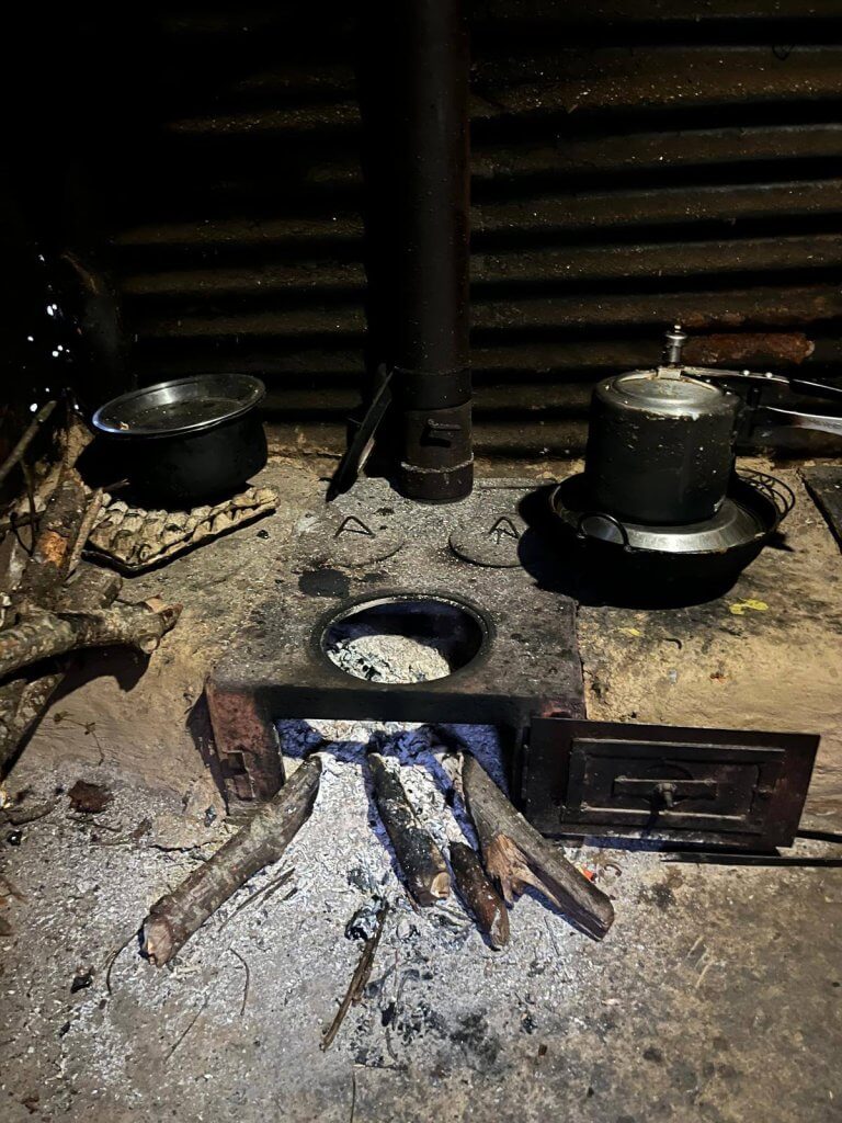 The metal wood-burning stove is installed on the floor without any surround added, therefore any ash can spill out.